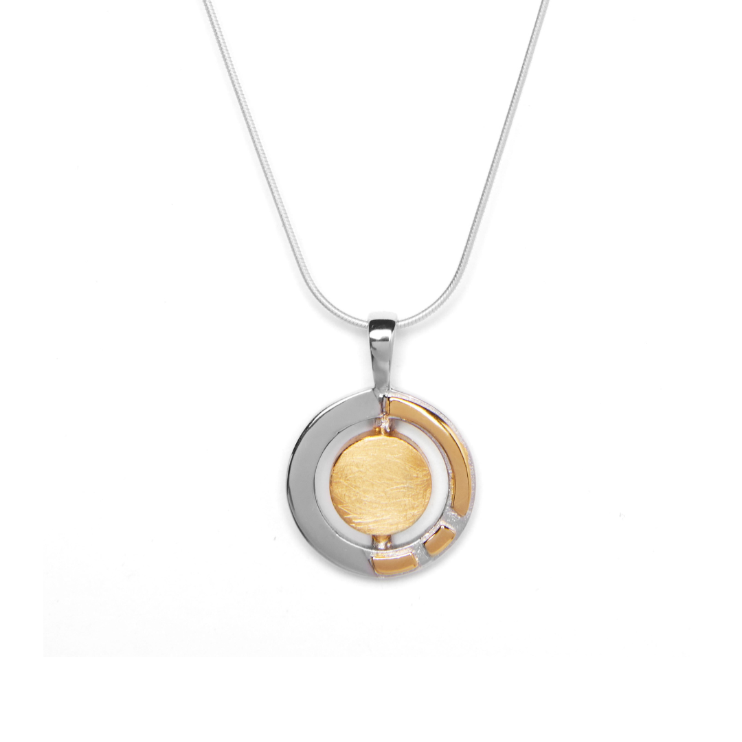 The Urú Small Pendant & Chain by Gallardo & Blaine Designs features a round sterling silver pendant with a brushed gold-toned center, shiny silver outer ring, and gold accents inspired by classic Irish jewelry.