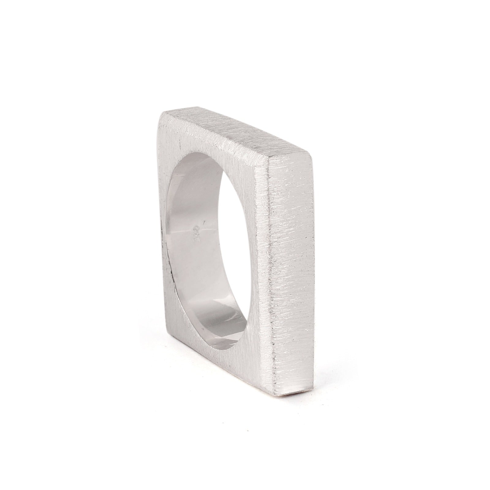 A William Silver Ring with a modern, square shape from The Collective Dublin. Crafted from 925 sterling silver, it features a smooth, brushed metal finish that creates a sleek and contemporary look. The wide band and geometric design lend it a unique, min
