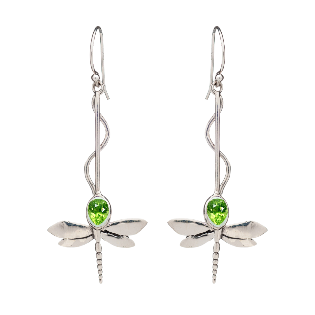 The Willow Earrings in Various Gemstones by Gallardo & Blaine Designs are silver dragonfly danglers with green gemstone bodies, curved decorative hooks, and intricately detailed wings.