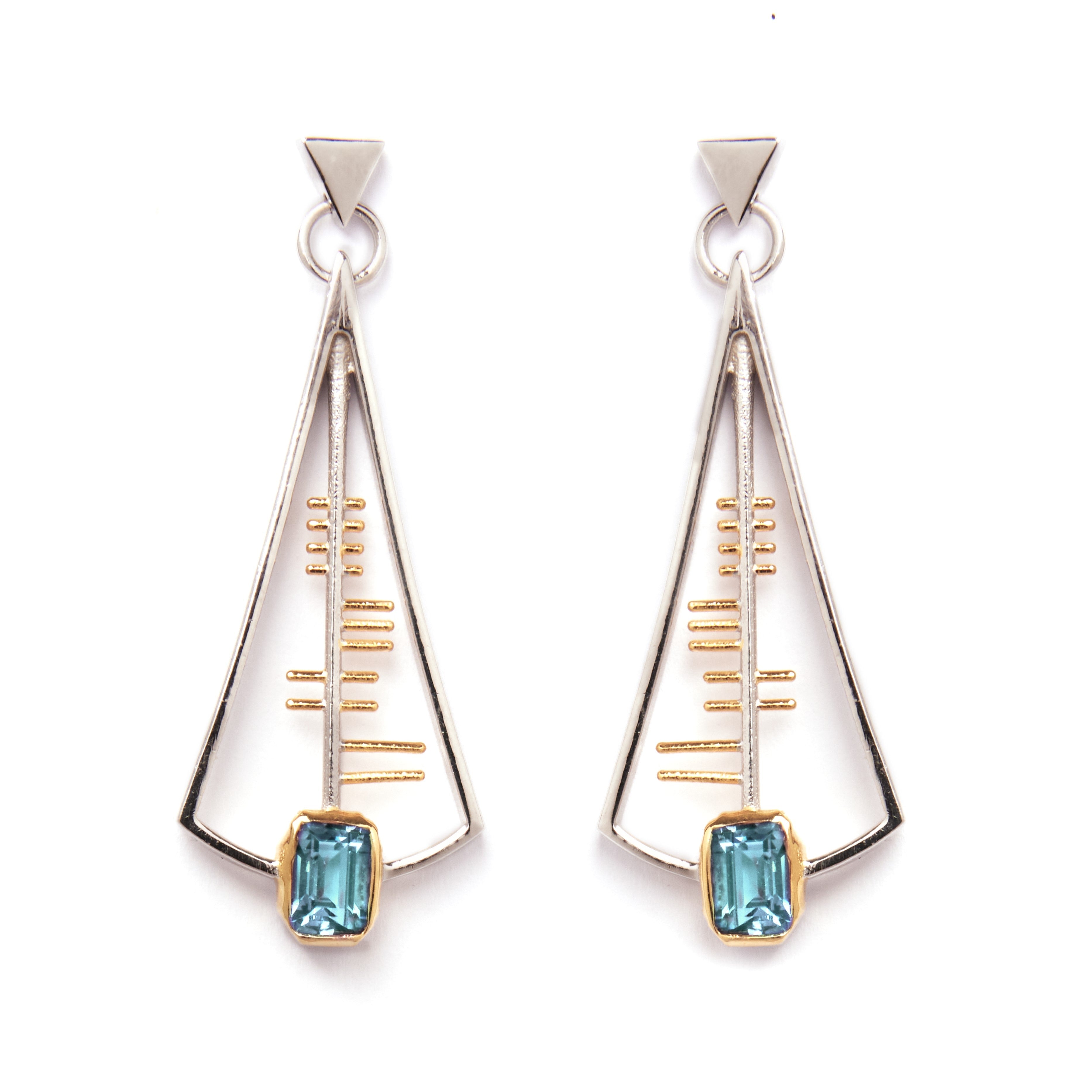 The Adeline Earrings by Gallardo & Blaine Designs feature a geometric, Art Deco-inspired design with a triangular sterling silver frame accented with gold and centered around a striking rectangular blue gemstone at the base. These earrings showcase a slee