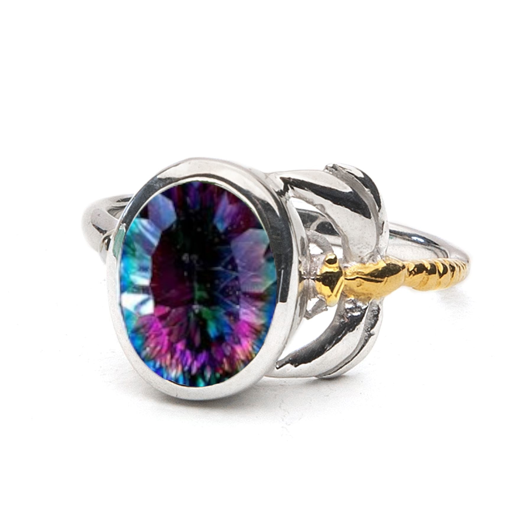 A Gallardo & Blaine Designs Daydream Ring in various gemstones featuring a multicolored, oval-shaped gemstone in the center with shades of purple, blue, and green. The delicate and dainty design includes intricate golden anchor details on either side of t