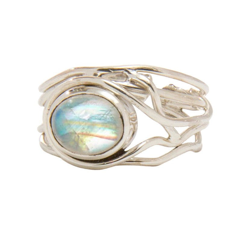 A Fossil Ring in silver & various gemstones, by Gallardo & Blaine Designs, features an intricate, vine-like design with a large, round, iridescent stone at its center. This adjustable ring displays a spectrum of colors, including shades of blue, green, an