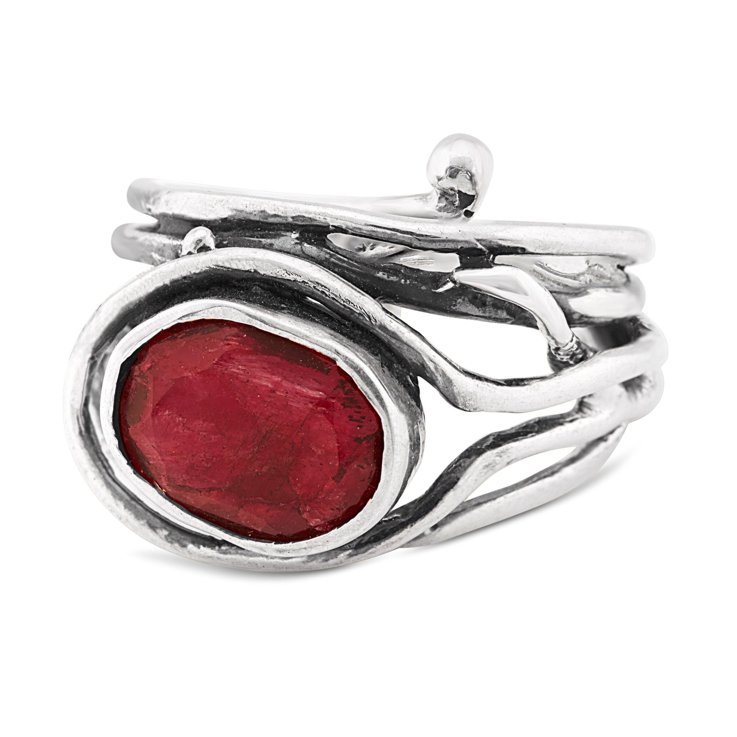 A Gallardo & Blaine Designs Fossil Ring in silver & various gemstones featuring a large, oval-shaped red gemstone set in an open, intertwined metal design. The adjustable ring has an organic, rustic aesthetic with uneven and textured silver strands wrappi