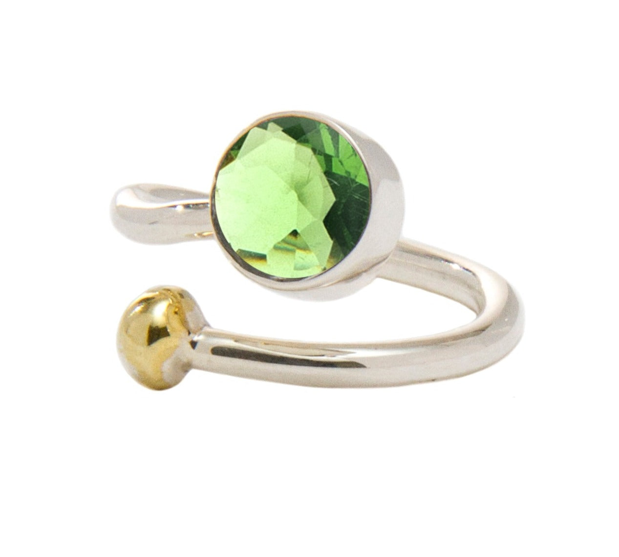 A shiny, open-ended silver and gold jewelry piece features a round, faceted green gem on one end and a small gold ball on the other. This elegant Honeysuckle Ring in Silver Gold & gemstones by Gallardo & Blaine Designs' minimalist design highlights the vi
