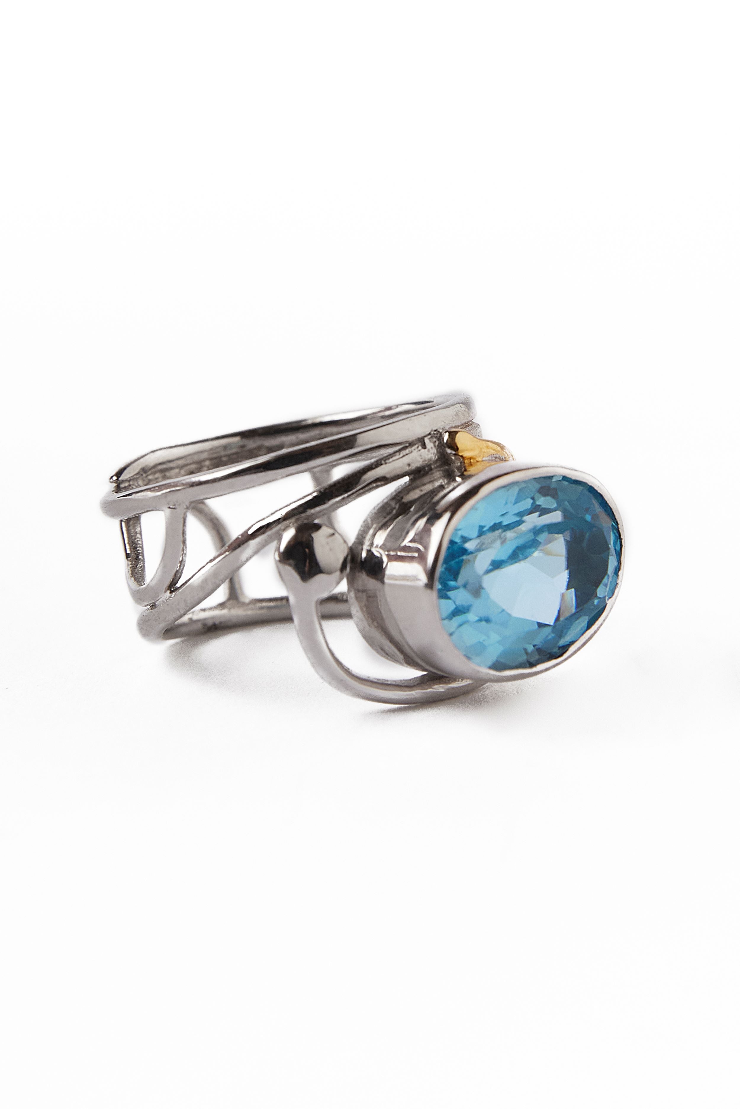 Gallardo & Blaine Designs' Horizontal Ring showcases a modern silver and gold band with intricate patterns, accentuating a prominent oval blue gemstone.