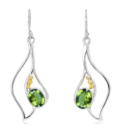 Introducing the Iris Earrings in various gemstones by Gallardo & Blaine Designs: a pair of elegant silver and gold earrings with a unique, abstract design. Each piece features an oval green gemstone surrounded by three small golden beads. The flowing, org