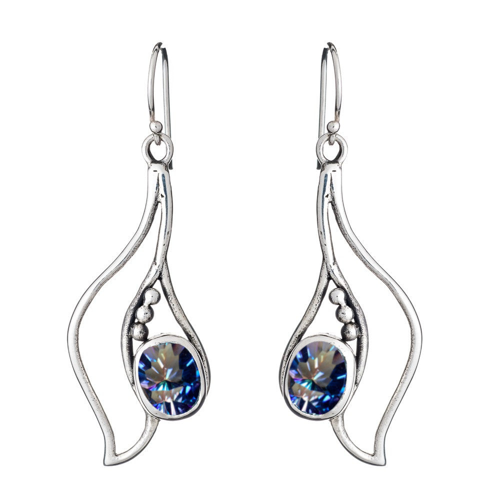 A pair of Iris Earrings in various gemstones with a wavy silver design, featuring a blue, sparkling gemstone at the center of each earring. The earrings hang by hooks and are accented with small metallic beads on one side. This exquisite piece is crafted 