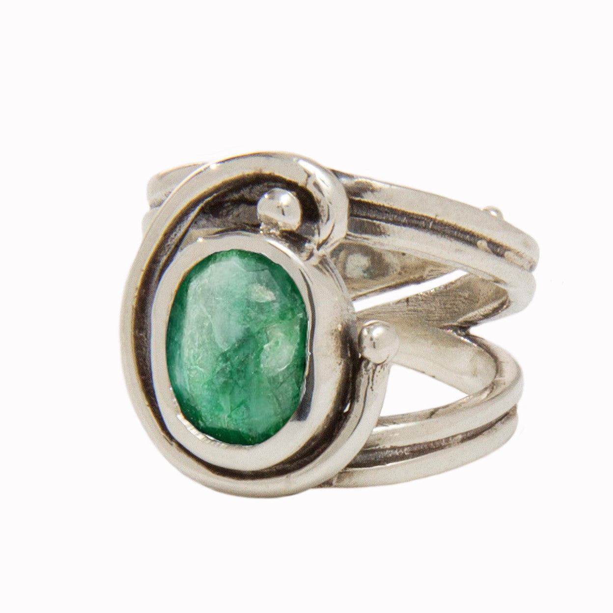 A silver Jasmine Ring in various gemstones featuring a green, oval-shaped stone set in a unique, swirling design. The band is split into three segments at the front, creating an open and artistic appearance around the gemstone, while its adjustable design