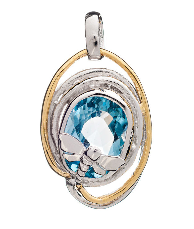 A Lagoon Pendant Small in various gemstones showcasing a large, faceted blue gemstone at its center by Gallardo & Blaine Designs. This unique piece features an intricate design with a small silver dragonfly perched on the gemstone, while the outer edge bo