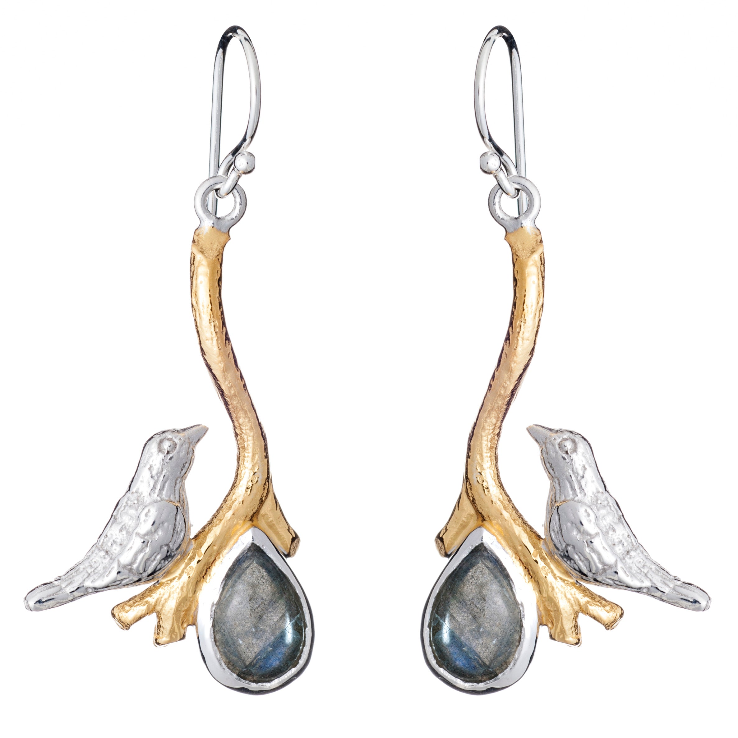 A pair of Lovebird Earrings in various gemstones featuring silver birds perched on golden branches. Below each bird hangs a teardrop-shaped pendant with a dark, reflective gemstone. These Gallardo & Blaine Designs dangle drop earrings have hook-style back