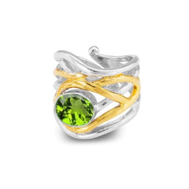 An elegant, adjustable ring featuring an intricate, dual-tone design with silver and gold bands intertwined. At the center, a vibrant green gemstone is set, adding a touch of brilliance to this medieval-inspired ornamental piece from Gallardo & Blaine Des