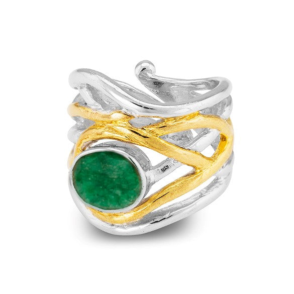 Introducing the Mayhem Ring in various gemstones by Gallardo & Blaine Designs: A silver and gold-toned ring featuring an intricate, intertwined design. The band showcases a prominent green gemstone as the centerpiece, adding a vibrant pop of color to this