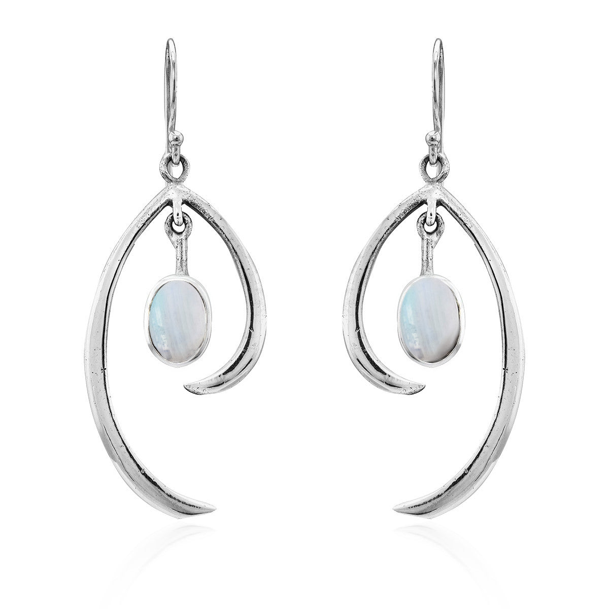 The Primrose Earrings in various gemstones by Gallardo & Blaine Designs are a pair of elegant sterling silver hook earrings with a teardrop shape, each featuring an oval moonstone at the center. The polished silver design elegantly curves around the shimm