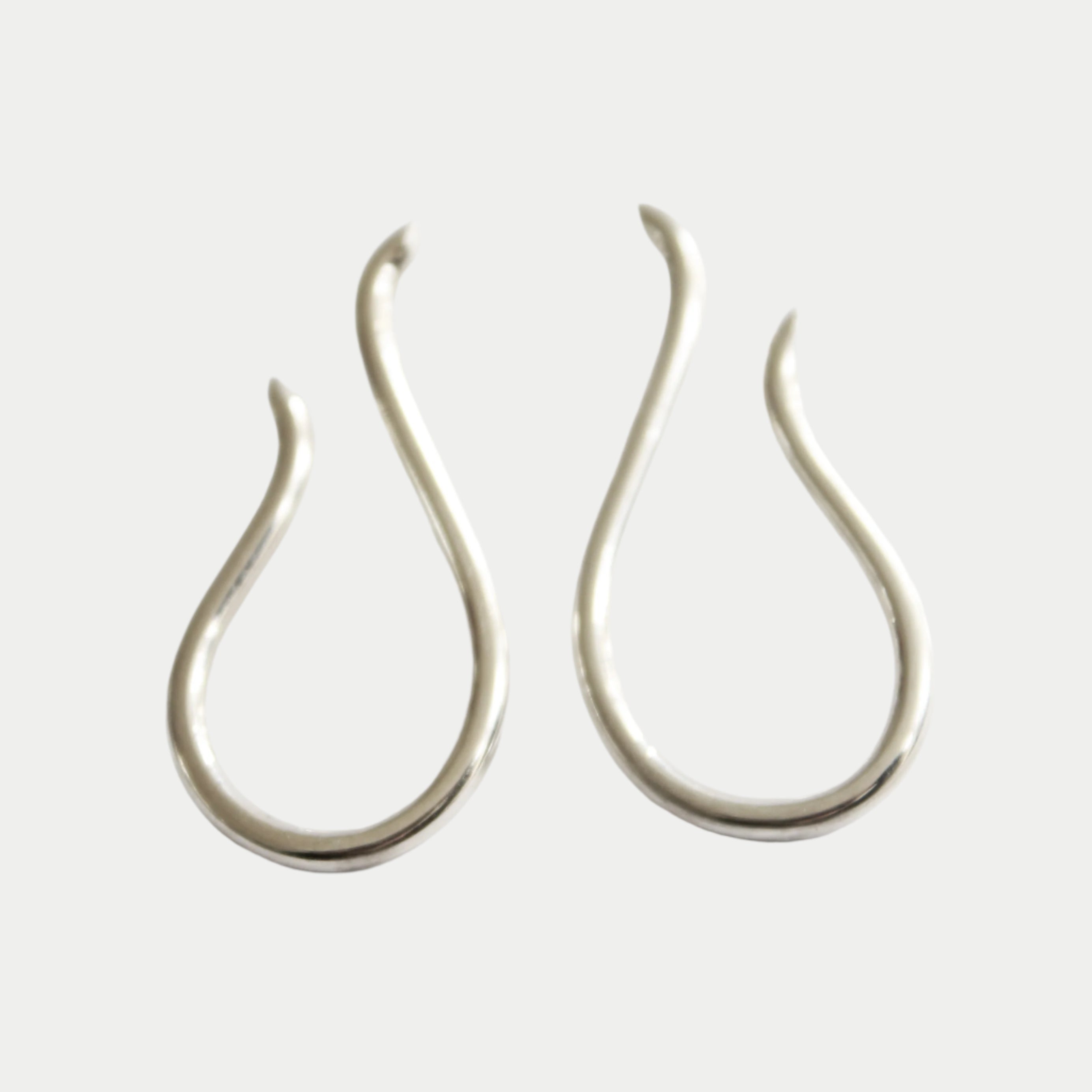 Sea Honey Studs by Gallardo & Blaine Designs, crafted in sterling silver with minimalist teardrop or open loop shapes featuring smooth curves and pointed ends, displayed on a plain white background.