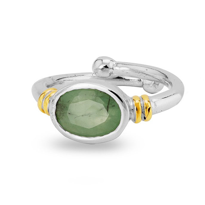 The Senna Ring in various gemstones by Gallardo & Blaine Designs is a silver adjustable ring featuring an oval green gemstone at the center. The ring has a polished finish with two small bands of gold on either side of the gemstone, adding a touch of cont