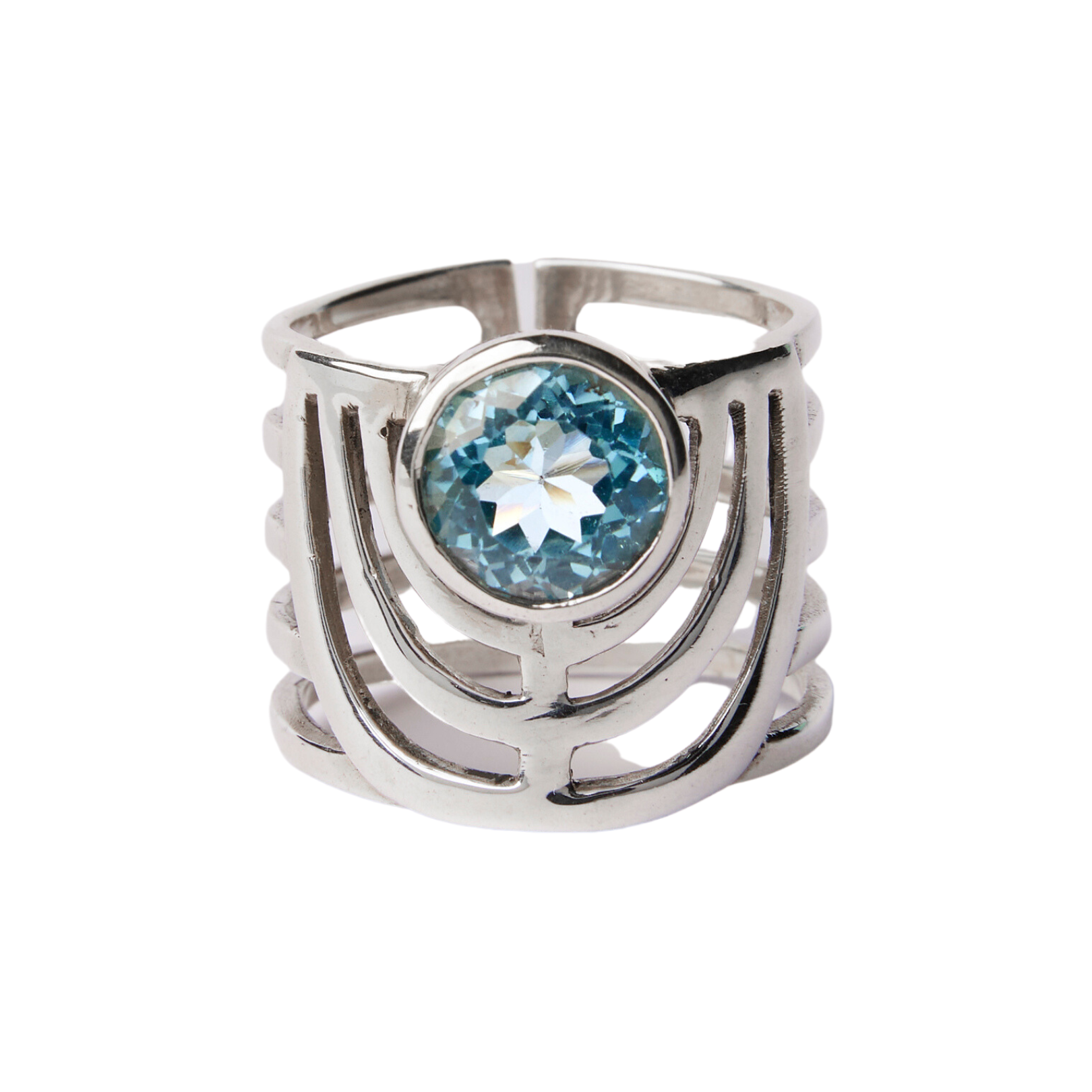 A bold jewellery design, this Solar Ring in various gemstones by Gallardo & Blaine Designs features a unique, openwork pattern with three parallel bands that converge and diverge around a centrally set, round blue gemstone. The intricate setting highlight