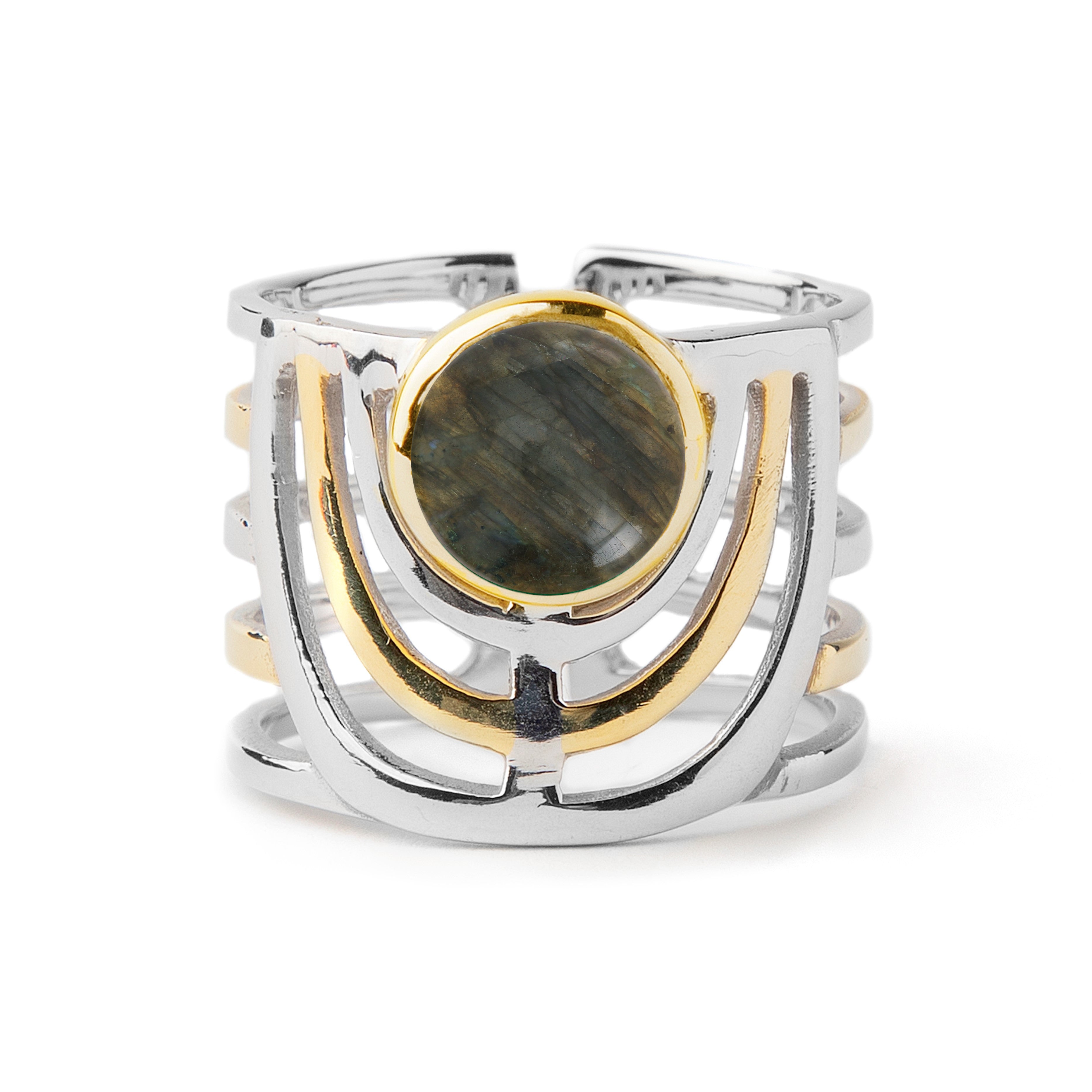 A stylish, silver and gold-toned chunky gemstone ring featuring a wide band with an intricate openwork design. The center displays a round, dark, marbled stone set in a gold bezel, adding a striking contrast to the bold jewellery design. This is the Solar