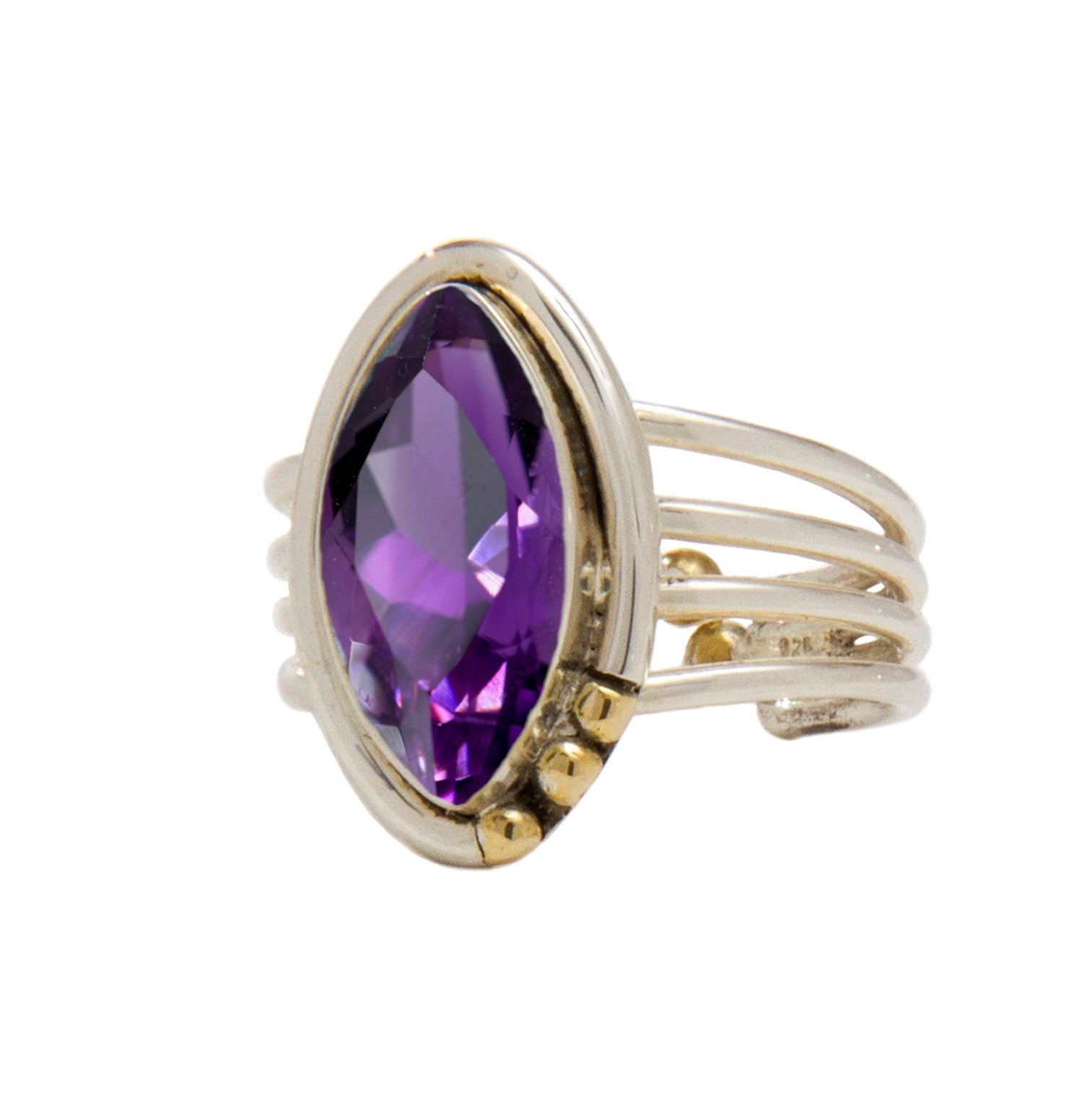 A gold Tulip Ring in various gemstones by Gallardo & Blaine Designs featuring a large, marquise-cut purple gemstone as its centerpiece. The band splits into four parallel strands, connecting to the stone with small gold accents on one side, adding an intr